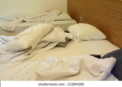 Interior Shot Of Motel Room With Unmade Bed