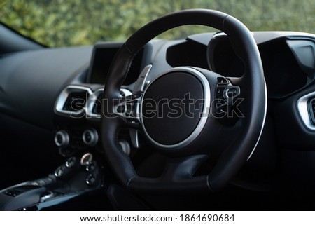 Interior shot of a sports car with black leather trim.
