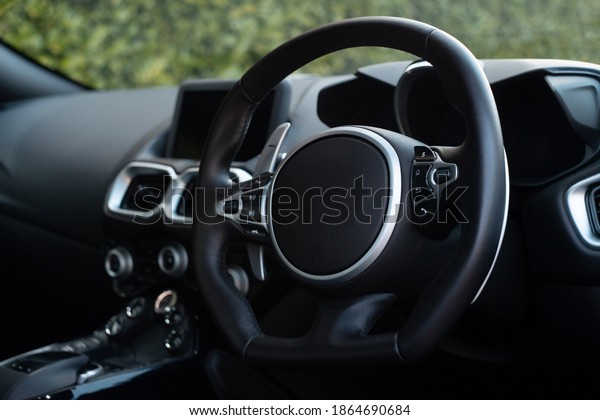 Interior\
shot of a sports car with black leather\
trim.