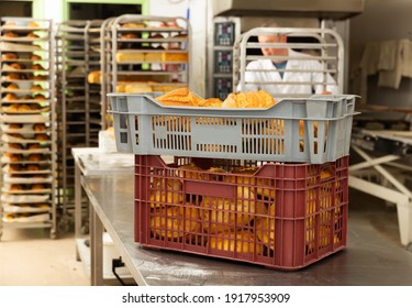 Interior of small bakeshop with box full of freshly baked bread. Breadmaking industry concept..