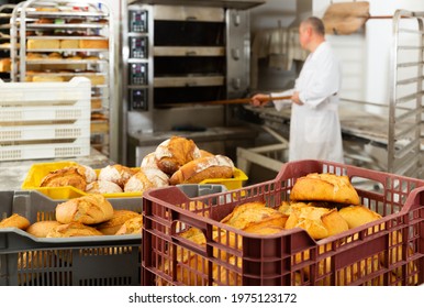 Interior of small bakeshop with box full of freshly baked bread. Breadmaking industry concept..