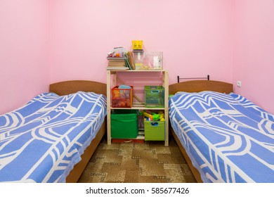 The Interior Of A Small Dorm Room With Two Beds And A Homemade Rack In The Middle