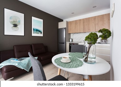 Interior Of A Small Studio Apartment With Integrated Bedroom Area, Brown Leather Couch 