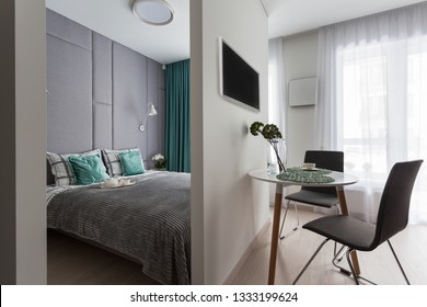 Interior Of A Small Studio Apartment With Integrated Bedroom Area, Brown Leather Couch 