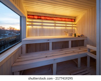 Interior of small wooden finnish sauna with window. Luxury private house.