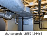 Interior space features extensive metal ductwork, piping installed in basement layout demonstrates careful planning for ventilation, airflow, emphasizing industrial design.