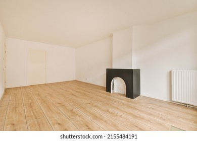 Interior Of Spacious Light Room With Fireplace And Elegant Chandelier Against Balcony Door And Windows