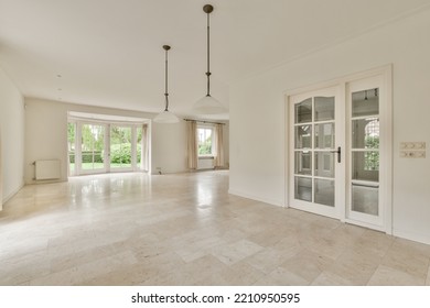 Interior Of Spacious Light Room With Fireplace Against Door And Windows