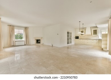 Interior Of Spacious Light Room With Fireplace Against Door And Windows