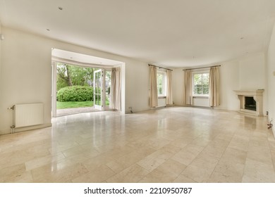 Interior Of Spacious Light Room With Fireplace Against Door And Windows