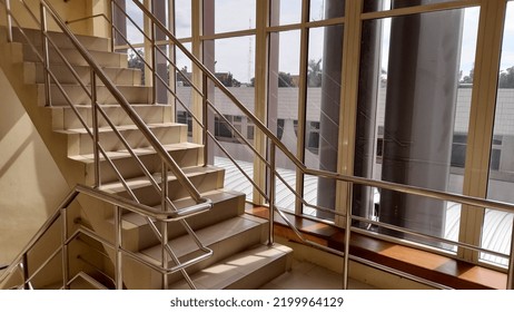 
interior staircase and large glass windows   yellow color due to sunlight