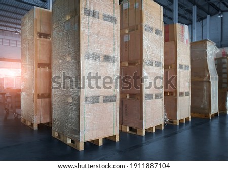 Interior of storage warehouse with stack wooden crates wrapped plastic. L-shape pallet corrugated paper cardboard Angle corner edge protector. shipping warehouse. cargo export  import.