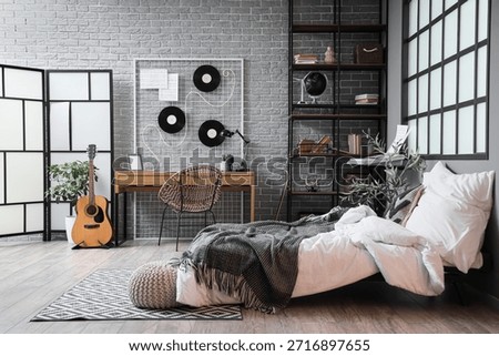Interior of student's room with shelf unit, table and musical instruments