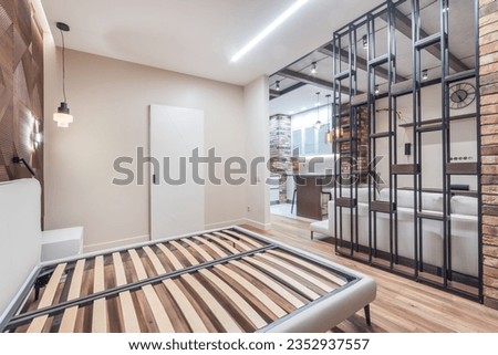 The interior of the studio apartment with an exclusive design. A space divided by a stylish 
partition into a bedroom and a living room.