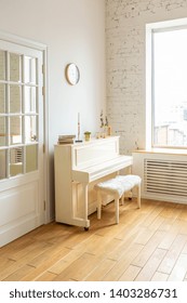 
the interior of the study in the style of a loft. Brick wall. large bright room with a seating area. sofa and piano