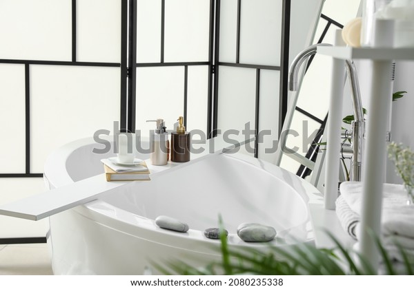 Interior of\
stylish bathroom with folding\
screen
