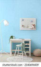 Interior Of Stylish Children's Room With Desk And Hanging Pegboard On Blue Wall