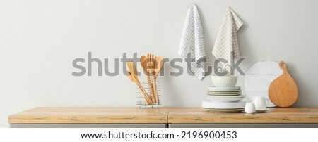 Interior of stylish kitchen with utensils and dinnerware on counter