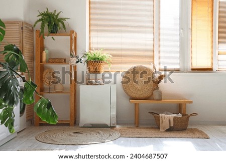 Interior of stylish laundry room with washing machine and houseplants