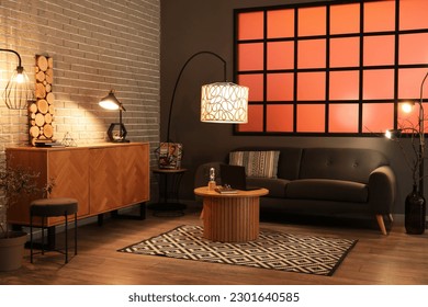Interior of stylish living room with black sofa and modern laptop on coffee table - Shutterstock ID 2301640585