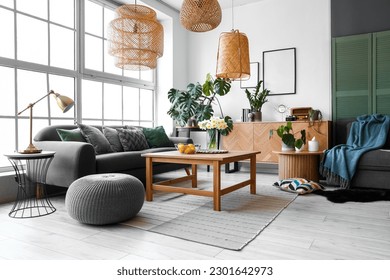 Interior of stylish living room with cozy sofas and table near big window - Shutterstock ID 2301642973