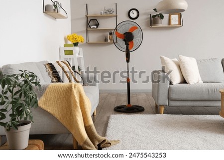 Interior of stylish living room with floor electric fan