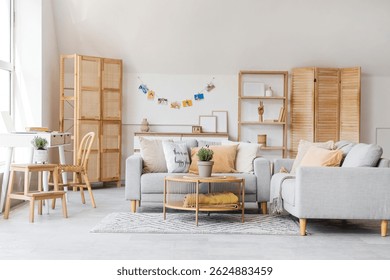Interior de la elegante sala de estar con sofá gris y flores de lavanda en maceta en la mesa de centro