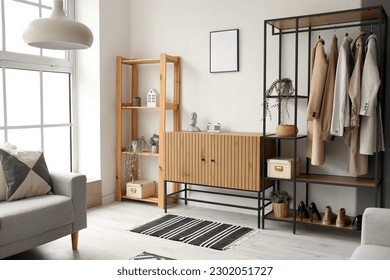 Interior of stylish living room with wooden cabinet, shelving unit and armchair - Shutterstock ID 2302051727
