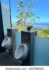 Interior Of Stylish Mens Bathroom With A Beautiful View Outside. The View Is Beach And Green Hills. Modern Design