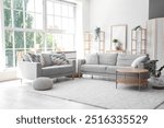 Interior of stylish modern living room with grey sofas and coffee table near big window