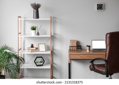 Interior Of Stylish Office With Modern Workplace And Shelving Unit