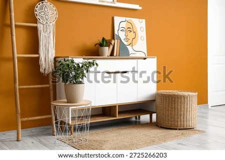 Interior of stylish room with commode, table and ladder