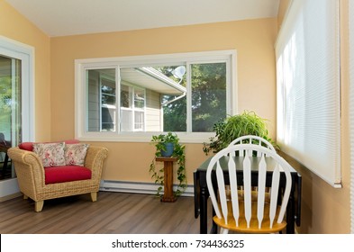 Interior Of Sunroom Addition To Home And Decor Including Small Table With Chairs And View Of Home Exterior From Window