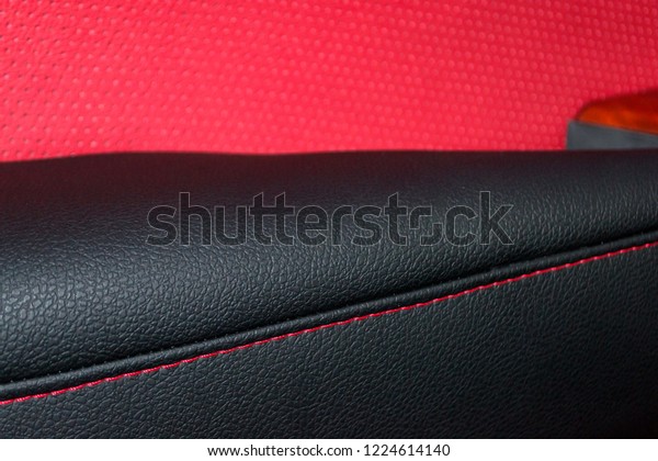 Interior of\
the SUV car with a rebuilt leather in red-black color in exchange\
for the old worn-out interior trim in the workshop for repairing\
the seat panels and steering\
wheels