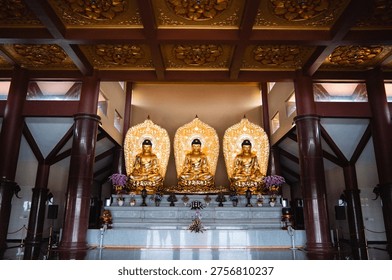 Interior temple altar with multiple Buddha statues and ornate ceiling, sacred space for cultural and religious themes