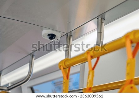 Interior of a train with security camera in the passenger compartment.