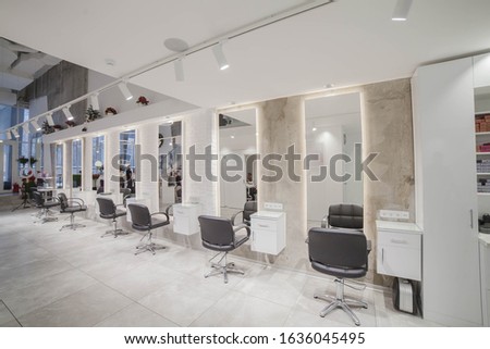 the interior of a trendy modern beauty salon in the loft style with large mirrors and windows