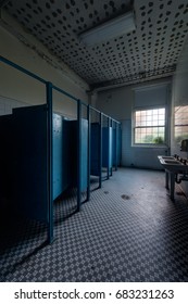 An Interior View Of A Blue Hued Restroom With Sinks And Stalls At An Abandoned School.