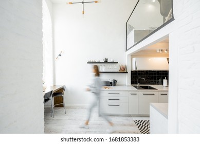 Interior view of the bright and modern kitchen with a blurred in motion human figure
