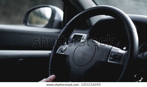 Interior view of car\
with black salon. Close-up Of A Man Hands Holding Steering Wheel\
While Driving Car