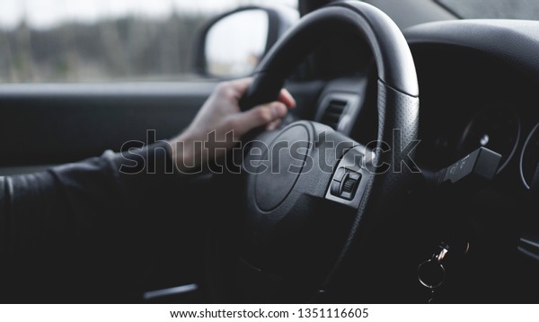 Interior view of car\
with black salon. Close-up Of A Man Hands Holding Steering Wheel\
While Driving Car
