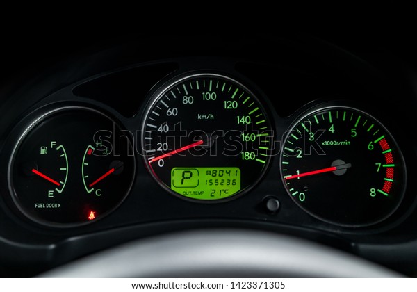 Interior view of car with\
black salon. Modern luxury prestige car interior: speedometer,\
dashboard and tachometer  with green backlight and other buttons.\
Soft focus 