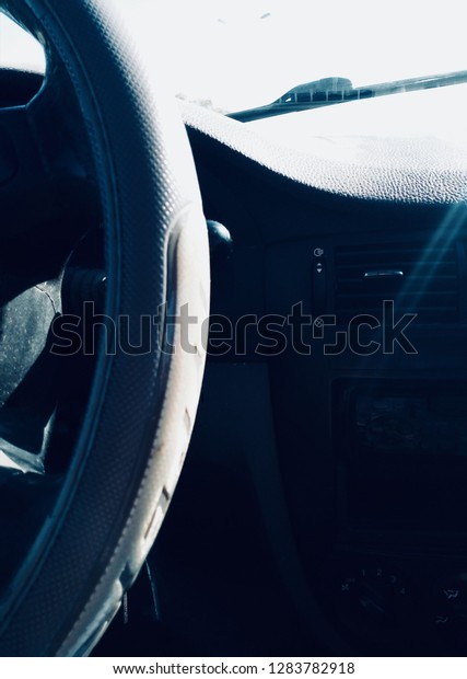 Interior view\
of a car dashboard and steering\
wheel