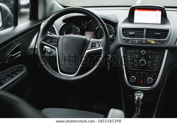 Interior view of car, luxury car\
steering wheel and dashboard with display or monitor\
screen.