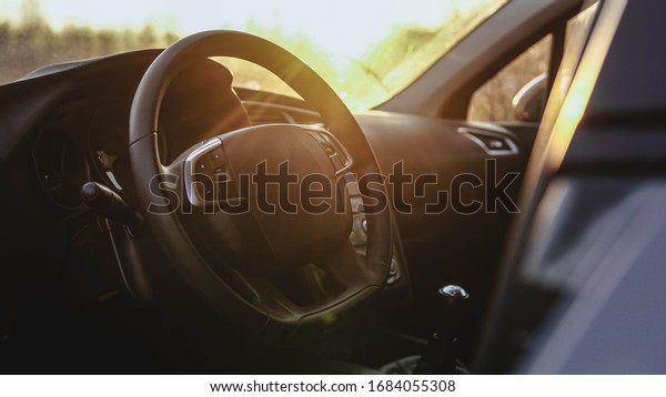 Interior view of car at sunset. Close up of\
steering wheel
