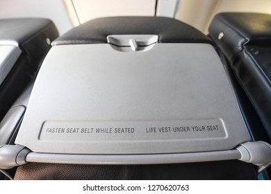 Interior view of a commercial airplane and its customer Table tray and seatback.