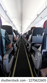Interior view of a commercial airplane with its seats and aisle.