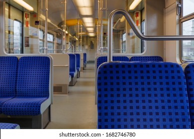 Interior view of a corridor inside passenger trains with blue fabric seats of German railway train system. Empty vacant passenger car inside the train.