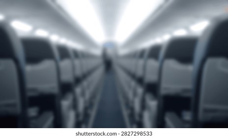 Interior view of an empty airplane cabin showing rows of seats on either side of the aisle, with overhead lights illuminating the space.