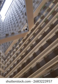 Interior view of a modern atrium with multiple balconies and natural light.